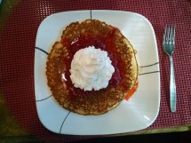 Pancakes with strawberries and whipped cream for breakfast